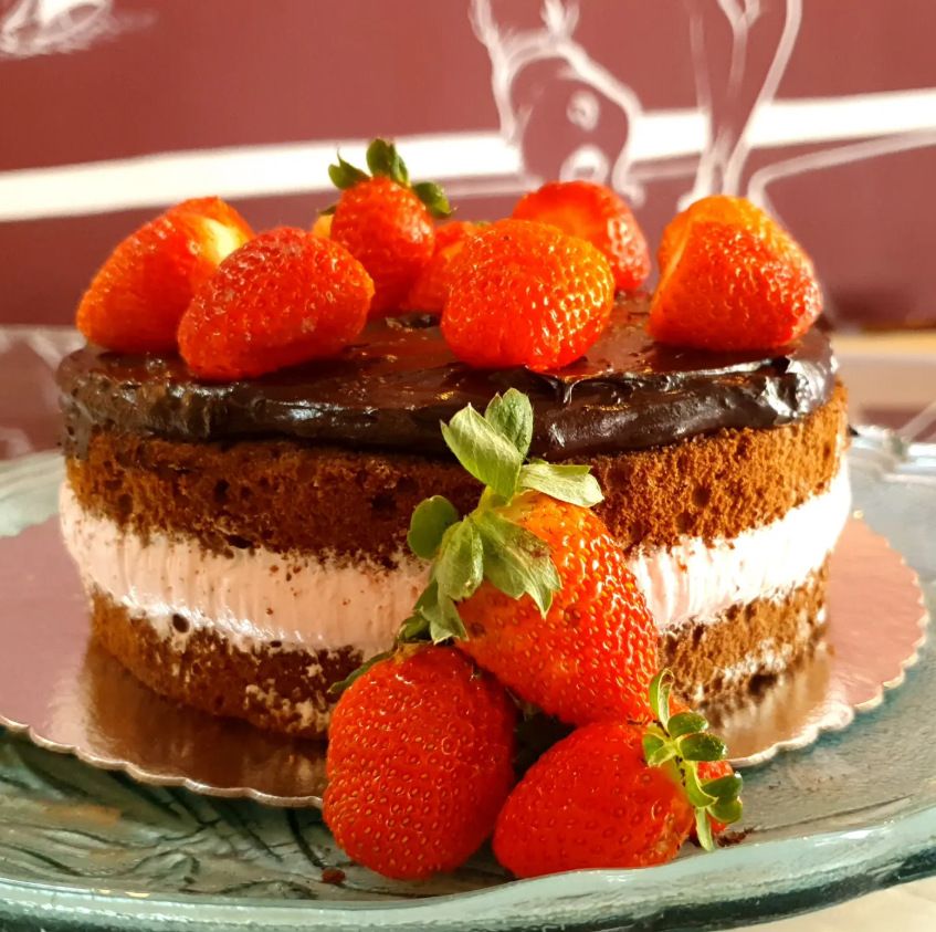 Bolo de chocolate com morangos diante da parede bordô ilustrada do salão