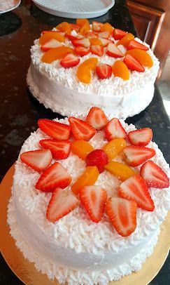 Dois bolos brancos decorados com morangos e pêssegos