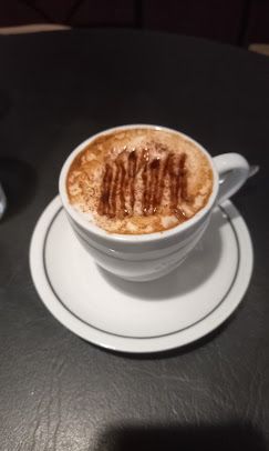 Xícara de café com espuma e fios de chocolate, vista de cima