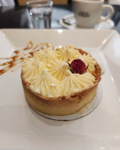 Torta com cobertura de creme e uma framboesa