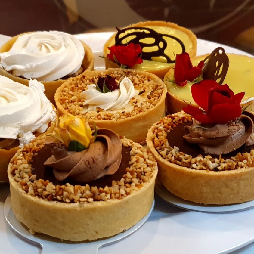 Tortinhas sortidas com chantili, chocolate e castanhas